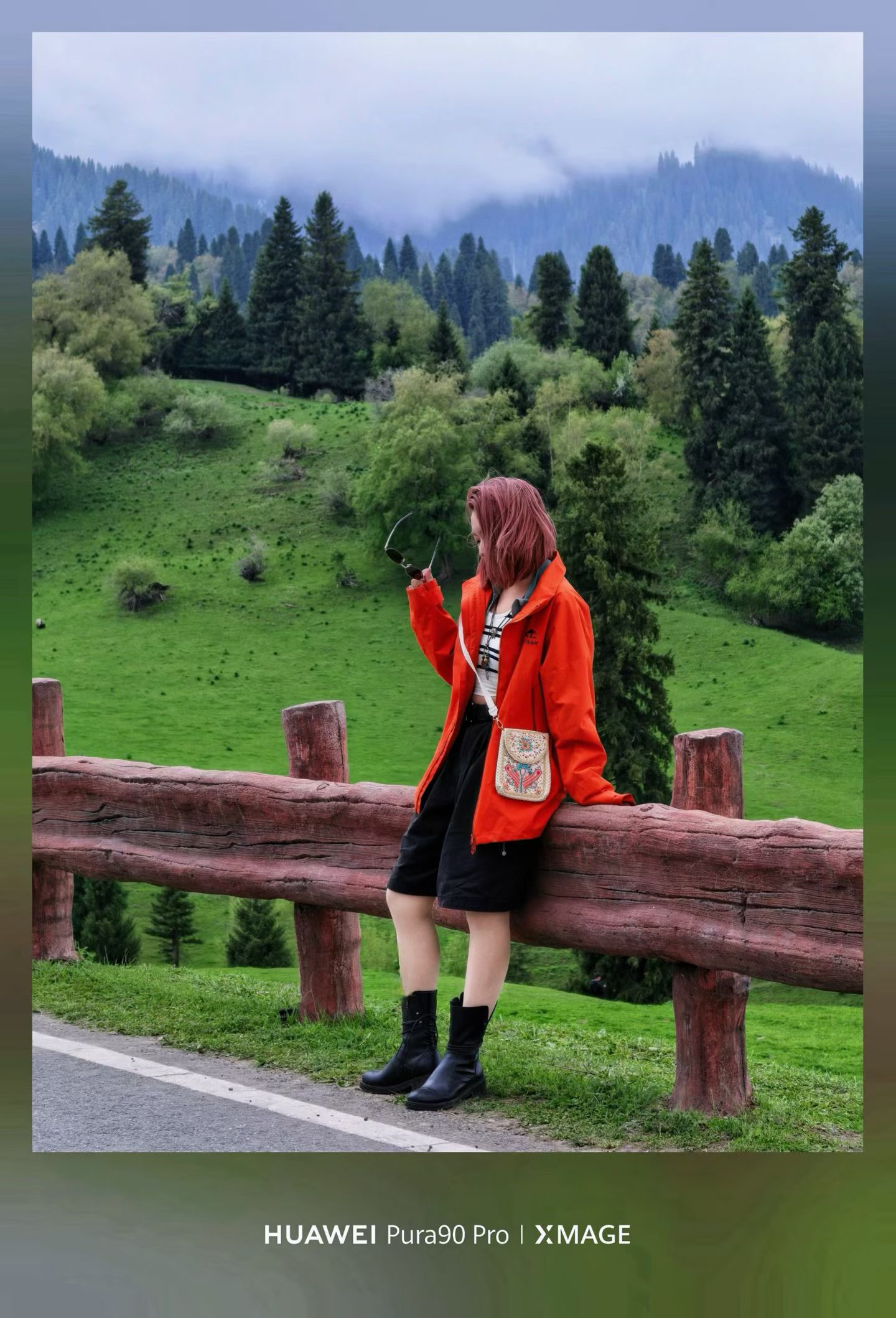 Hannah in a red jacket overlooking the misty green forest