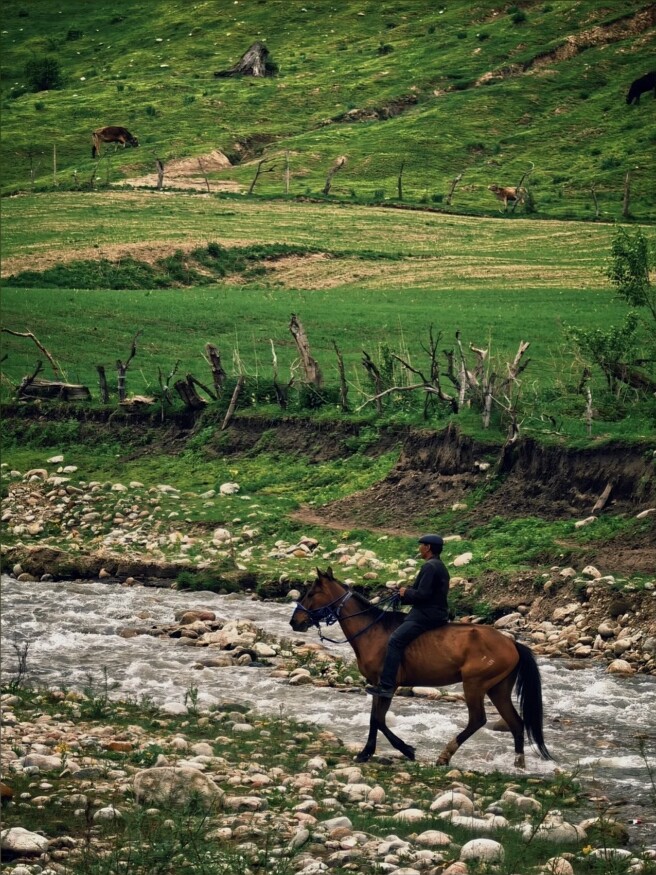 A rider crossing a mountain river in Qiaxi Forest Park